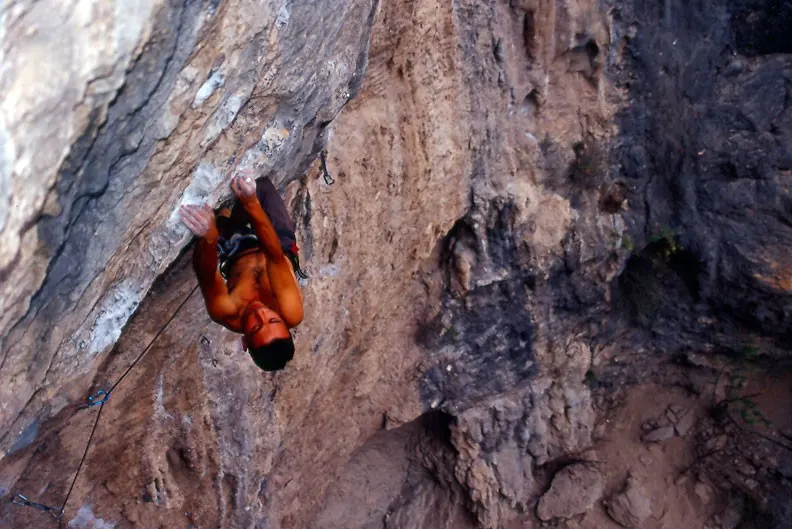Roped climber reaching a quickdraw on an overhanging rock face at Potrero Chico, Mexico, illustrative image