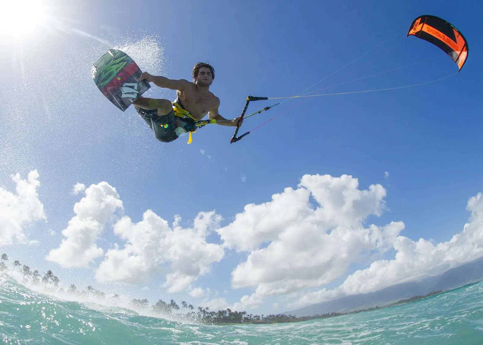 Kiteboarder jumping above the sea with board, control bar and kite visible, illustrative image