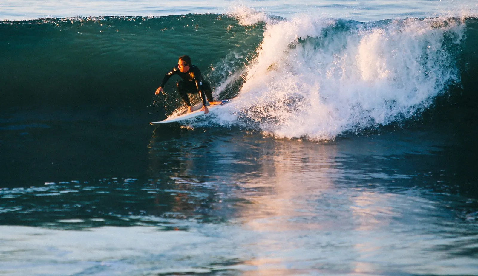 Surfer riding a breaking wave at Newport Beach, California, illustrative image